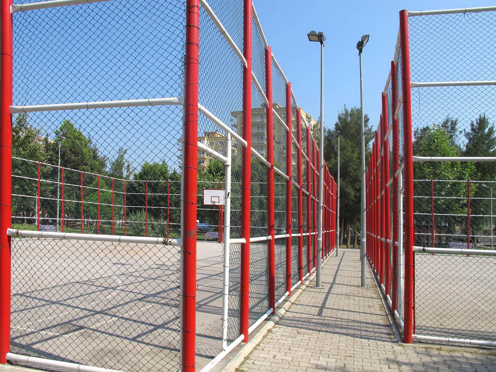 This image shows a professional chain link fence installed around basketball courts.